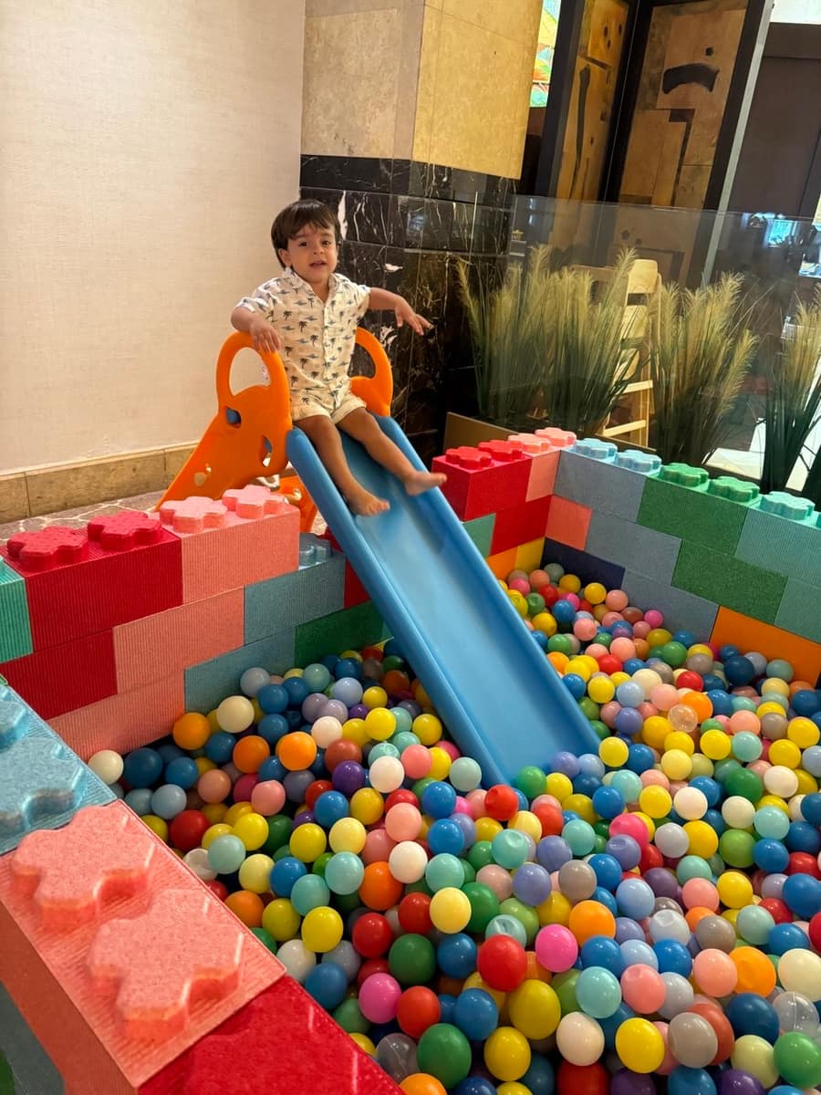Toddler sliding into a LEGO-block ball pit
