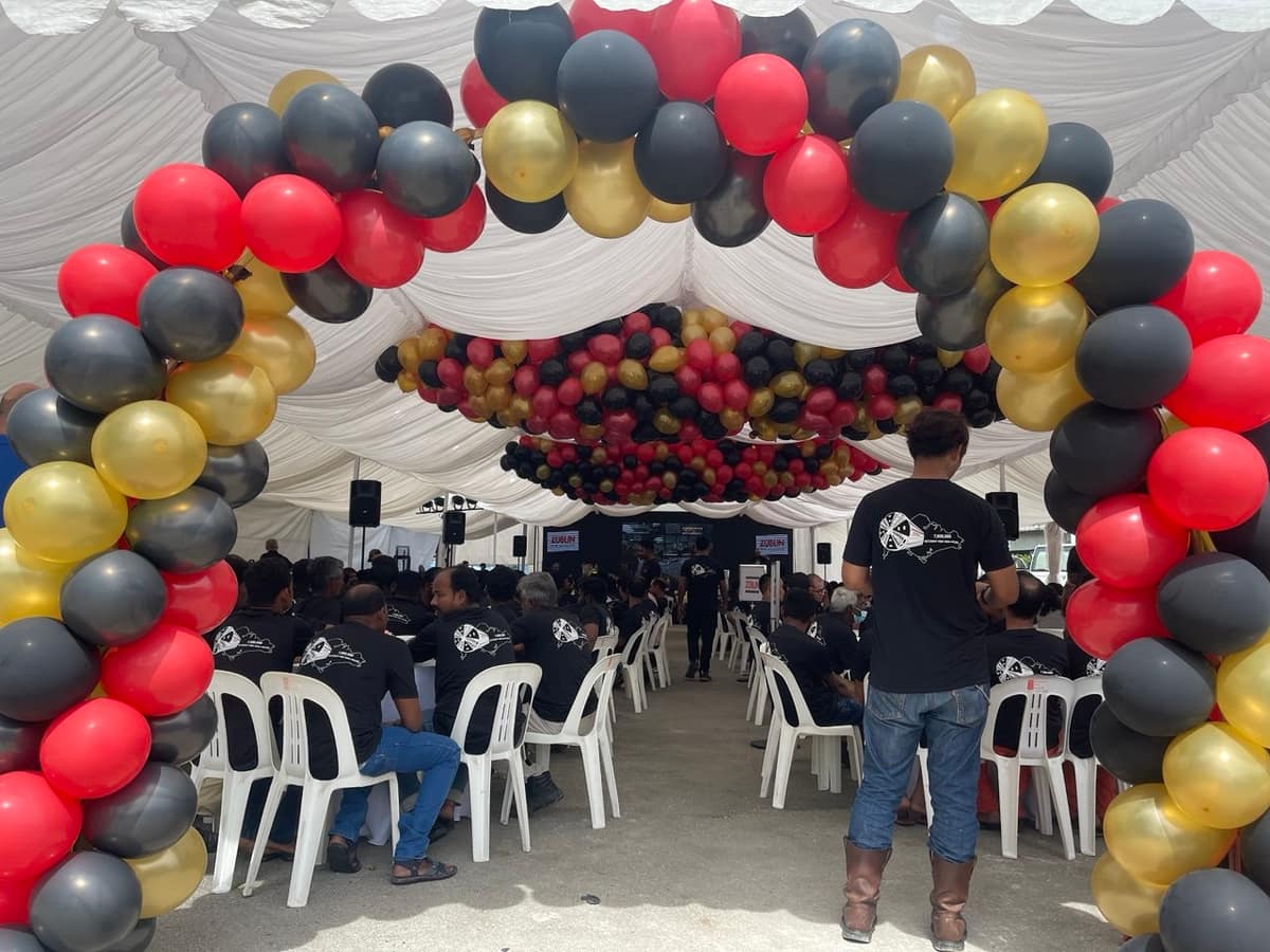 Black, gold and red balloon arch at a tent entrance