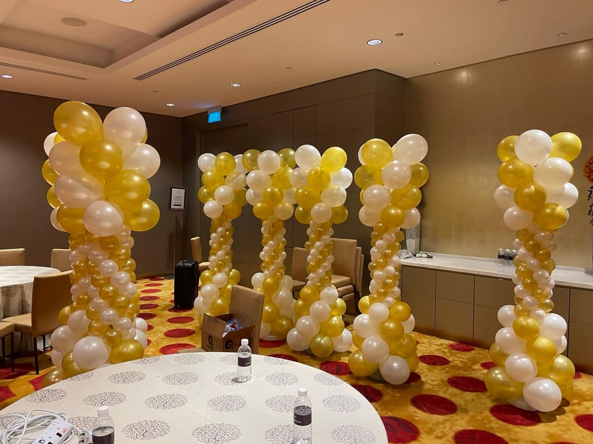 Gold and white balloon columns in a function room