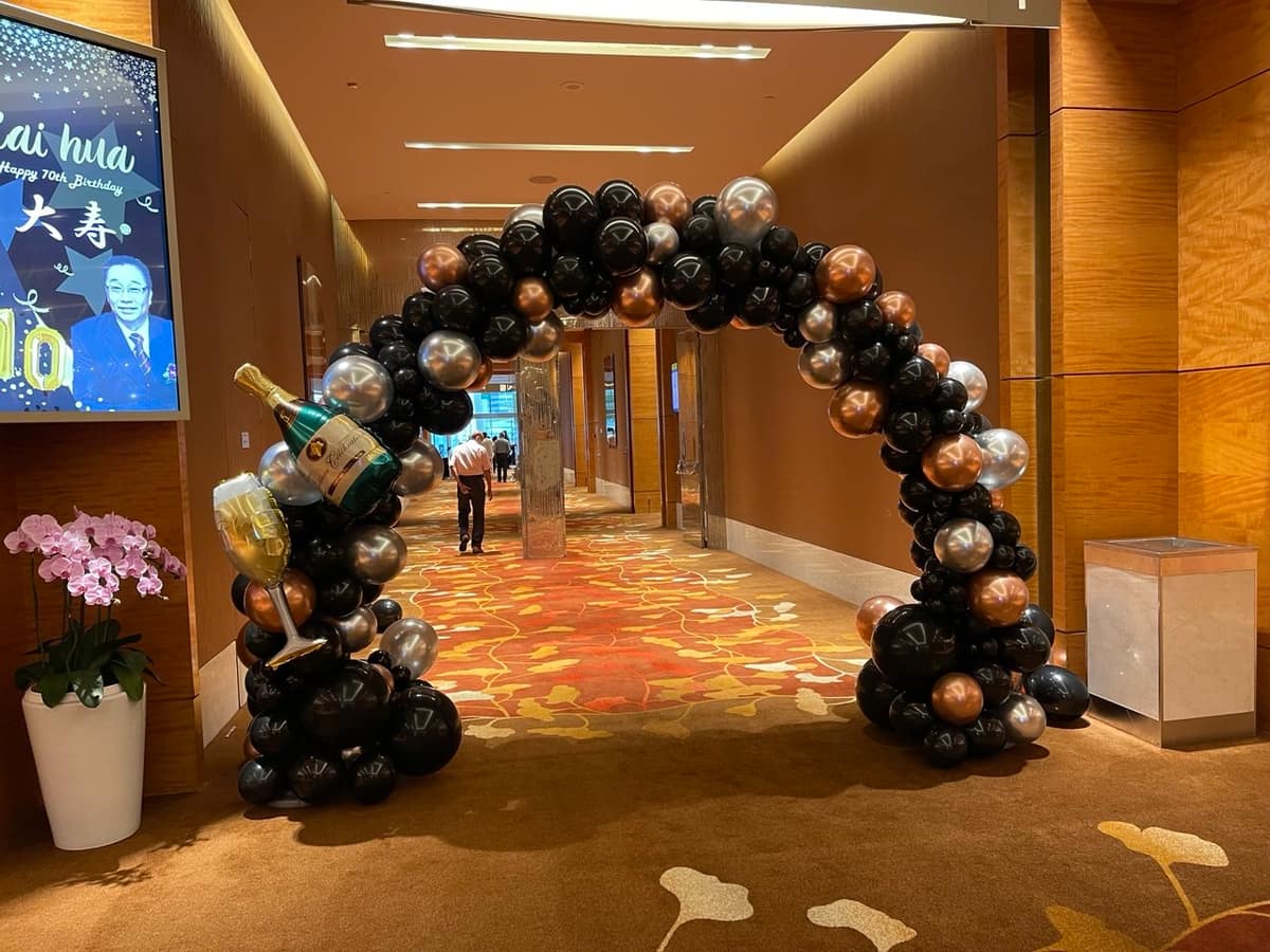 Rose gold balloon arch in a hotel corridor