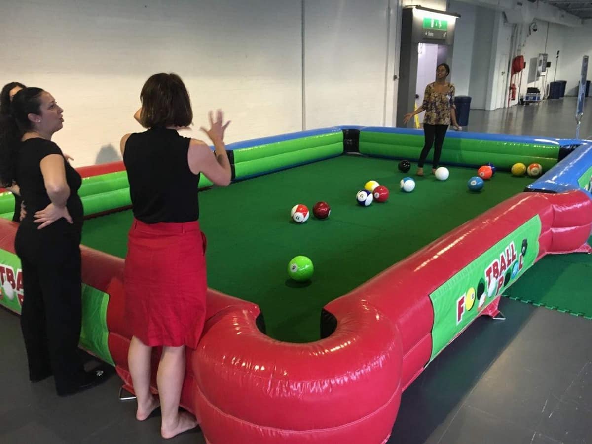 Giant inflatable pool table in play at an event