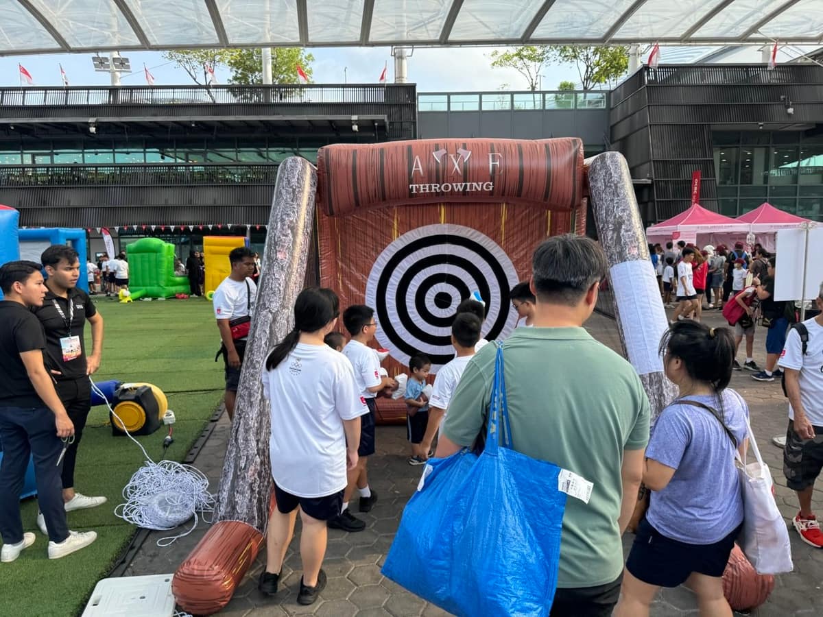 Queue at a wooden target throwing game booth