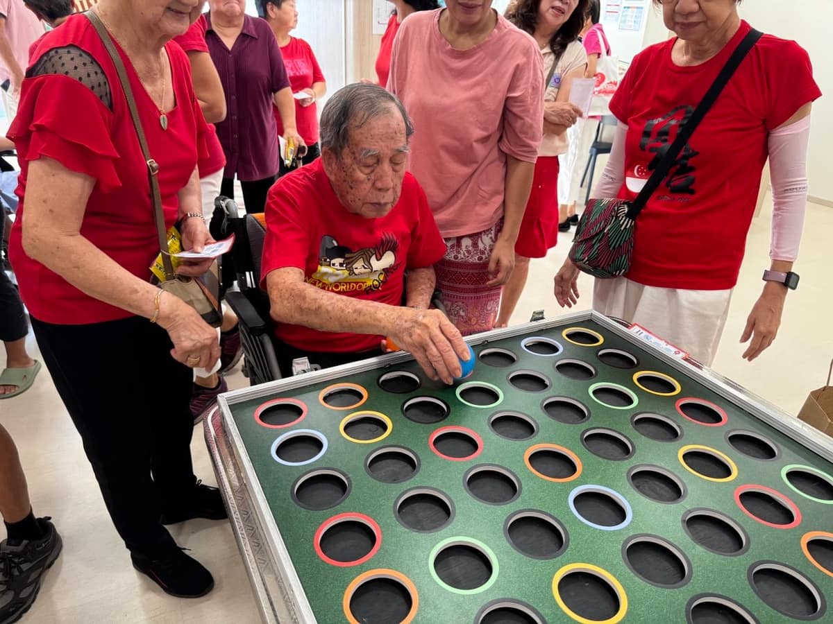 Elderly guest playing a ring peg board game