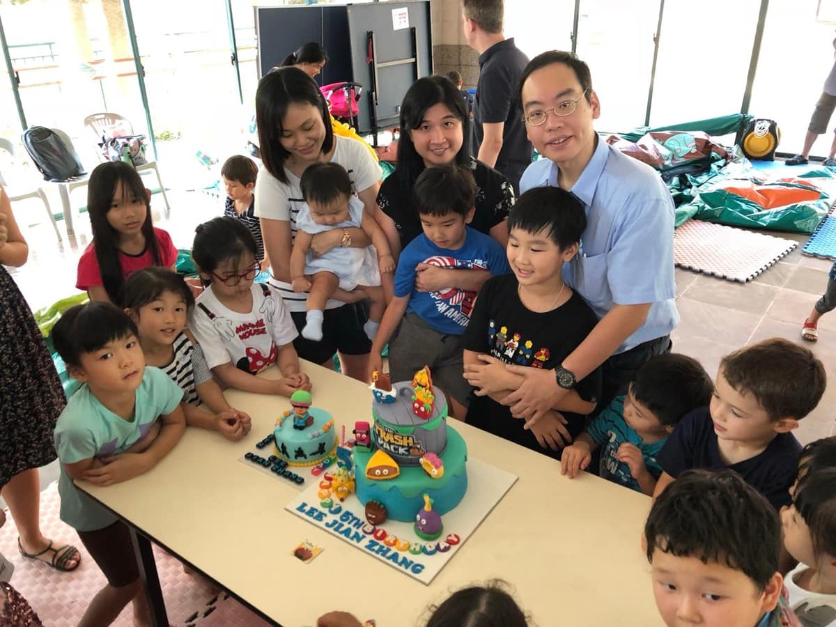 Group gathered around a birthday cake at a family event