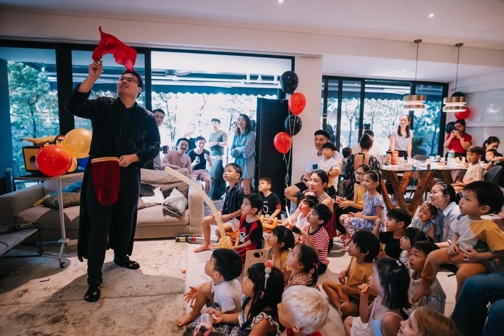 Magician performing to a seated family audience